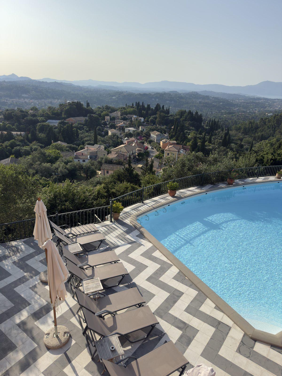 A hillside pool looking out over green hills and villages